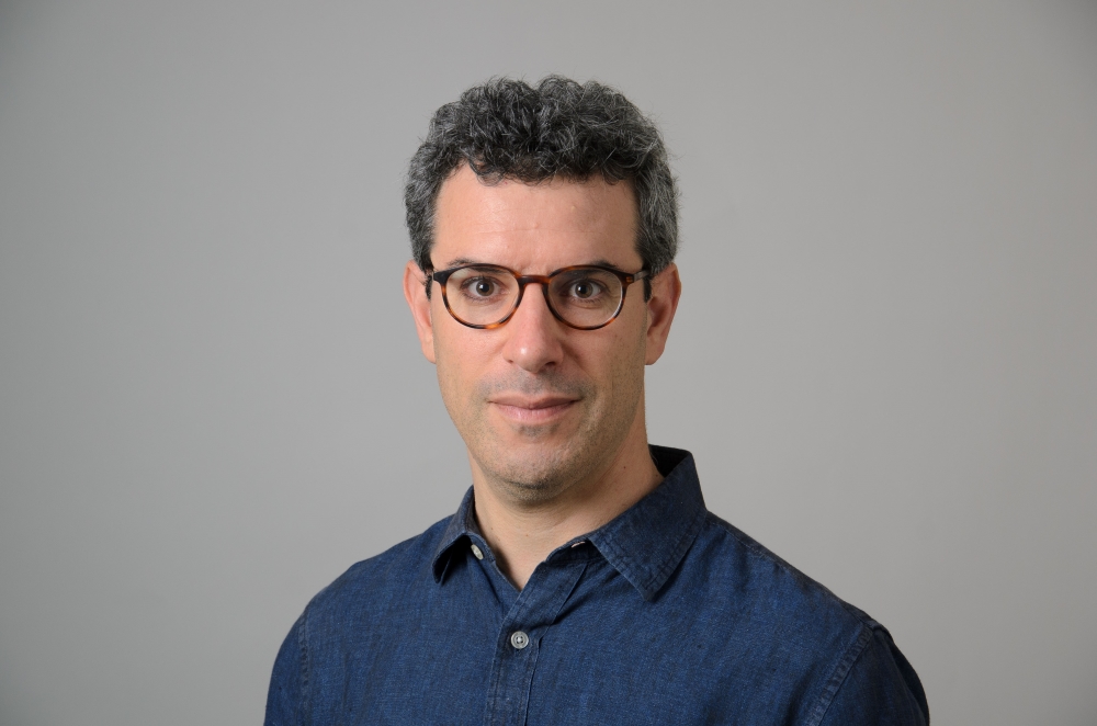 Portrait of Andy Horowitz wearing a blue collared shirt