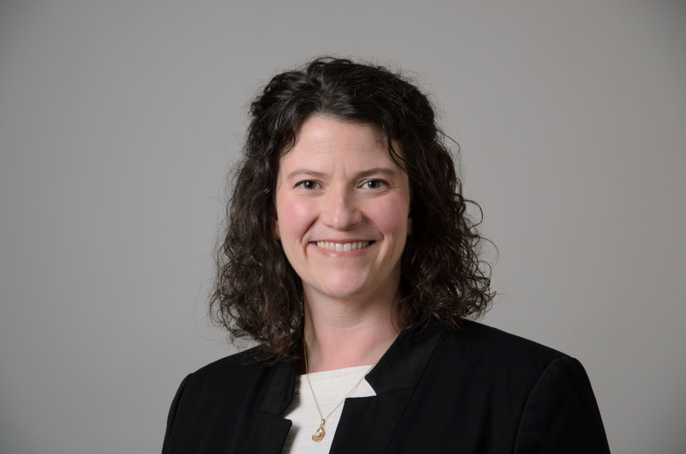 Portrait of Sarah Gray wearing a black blazer and a white shirt.